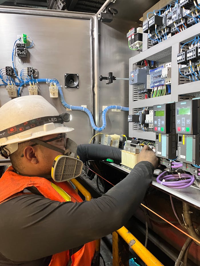 Engenheiro da C&M realizando manutenção em painel elétrico de alta precisão