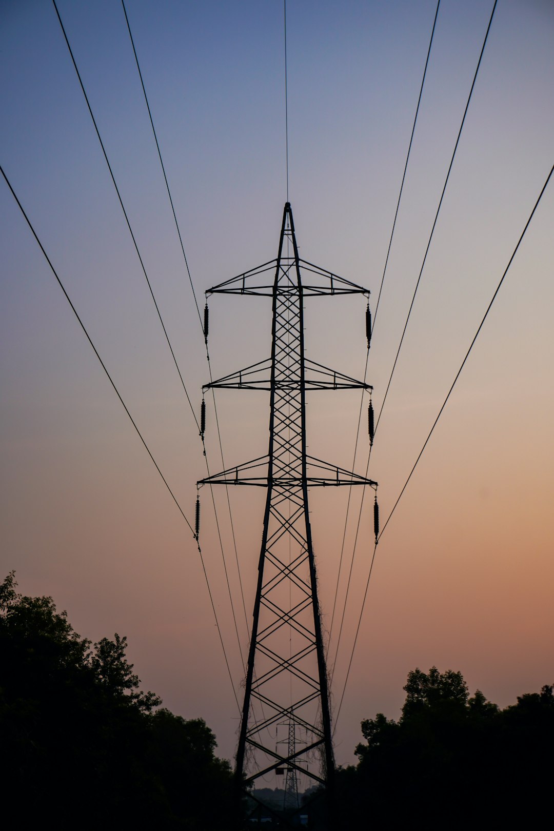 silhouette-of-a-power-pylon-against-a-twilight-sky-qjdqa7tlbqc